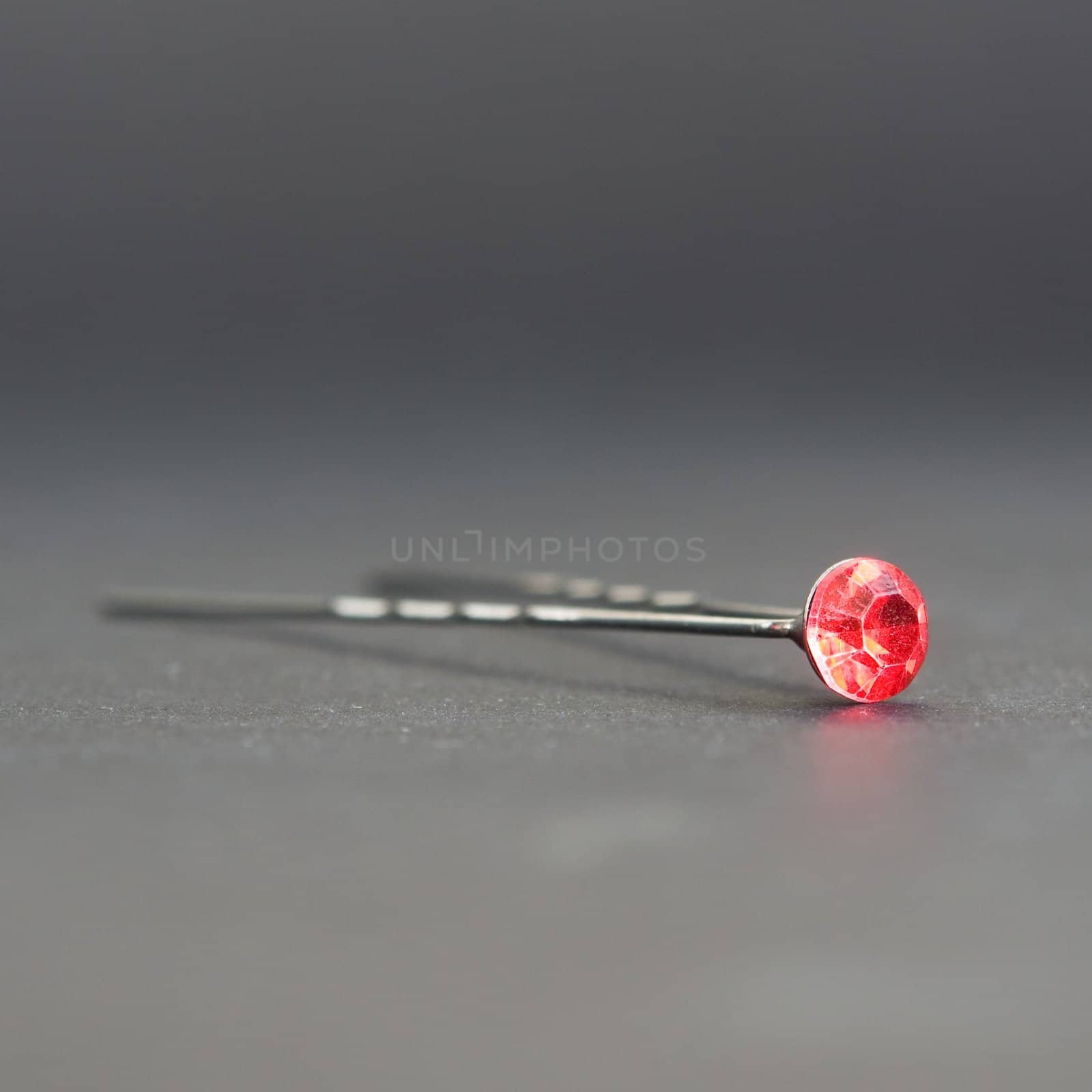 Hairpin with a ruby on a grey background