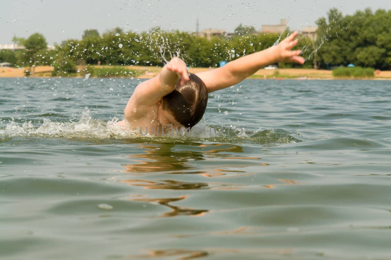 the little boy quickly swims the butterfly stroke