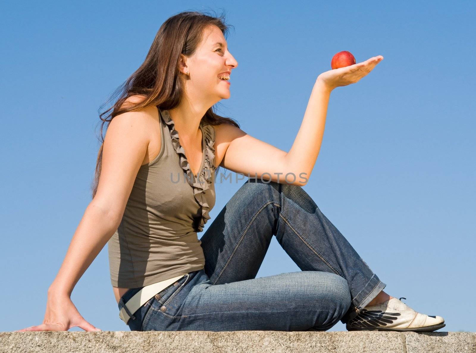 beautiful girl with red peach on a blue sky