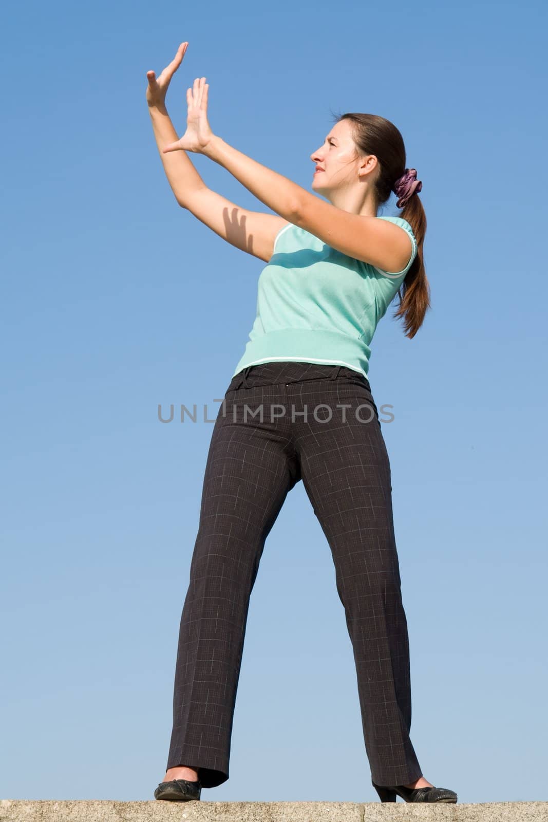Young woman stands, holding up her hands as if to ward something off
