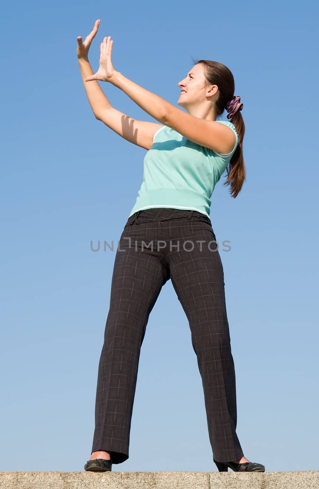 Young woman stands, holding up her hands as if to ward something off