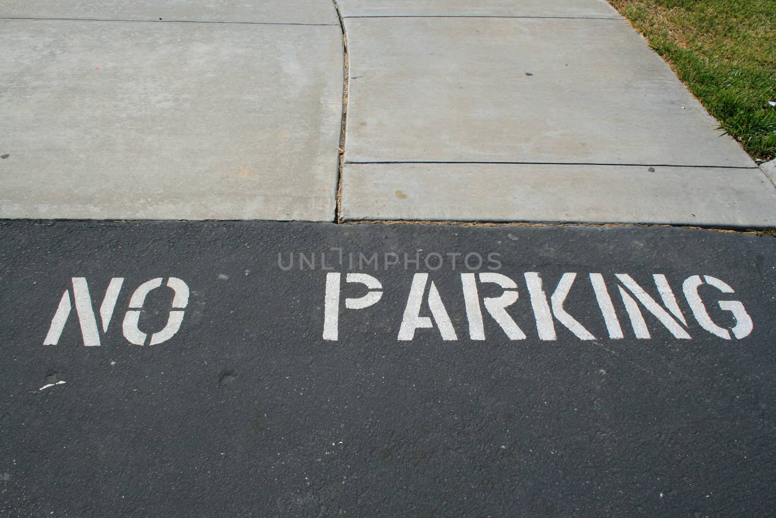 Close up of a no parking sign on a pavement.
