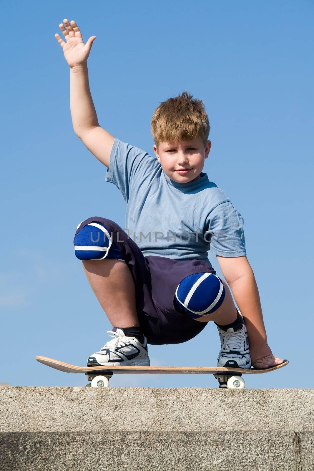 boy with skateboard on a blue sky
