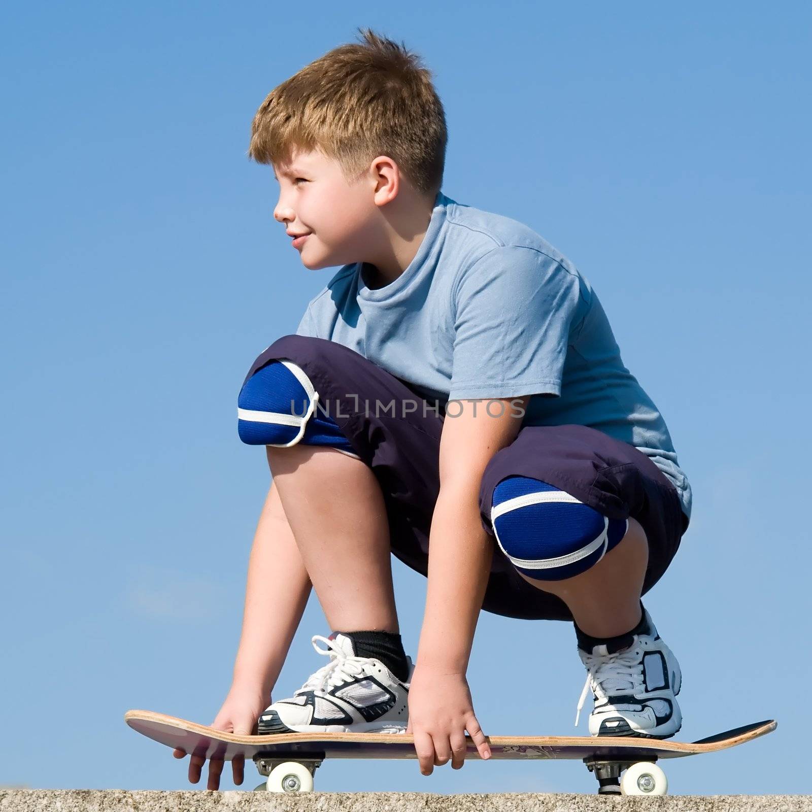 boy with skateboard on a blue sky