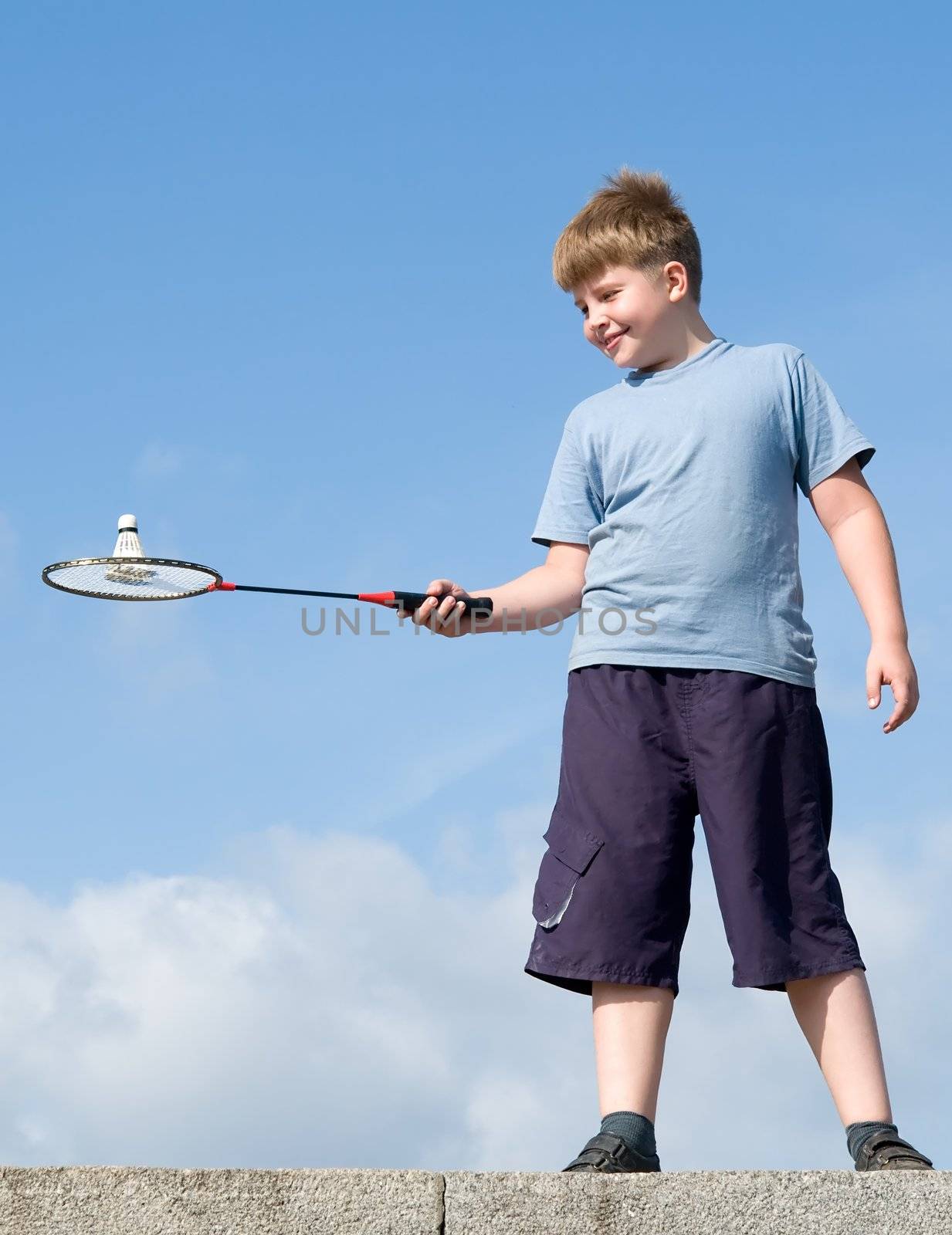 little boy playing badminton on a blue sky