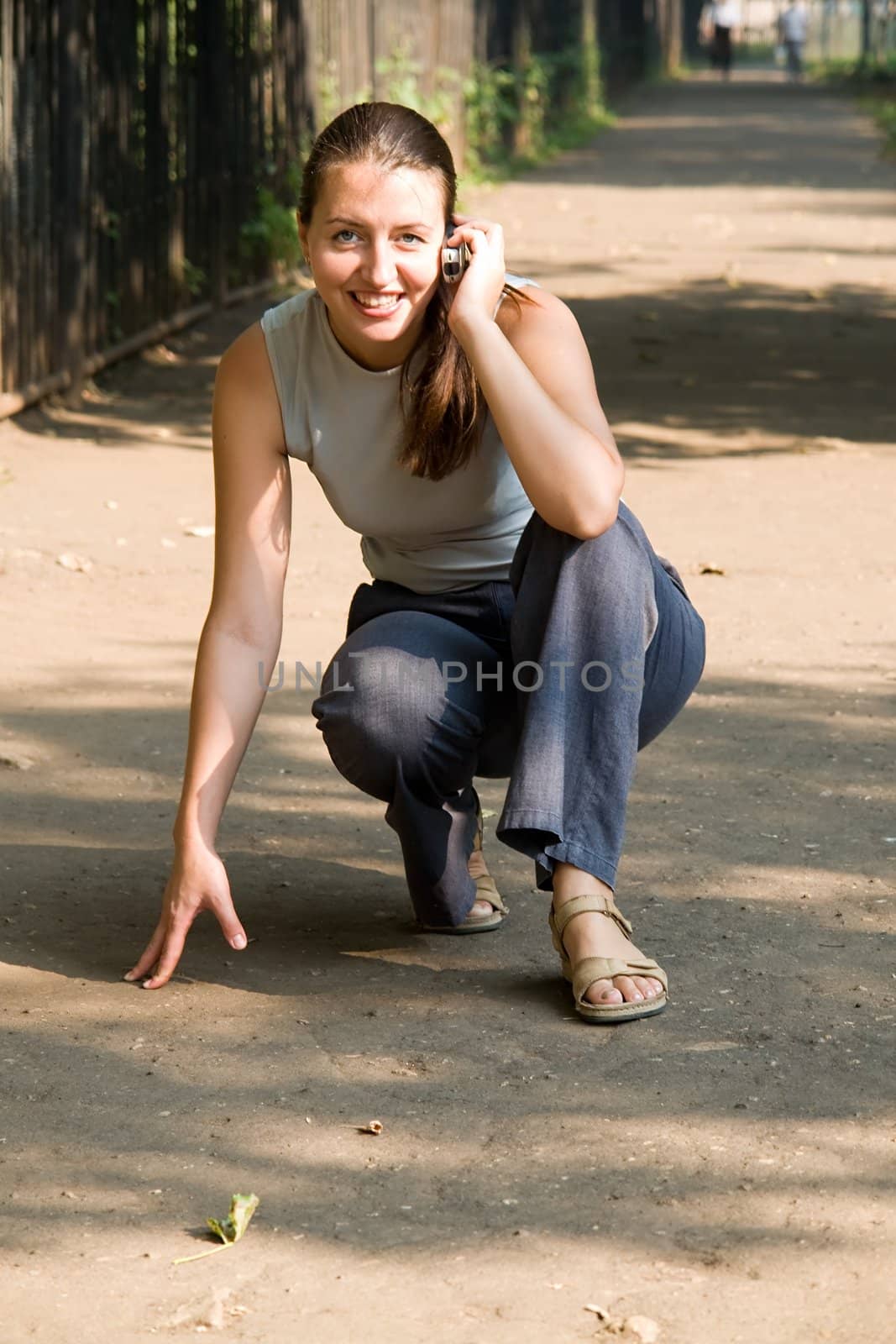 crouch start. girl with mobile phone is ready to run