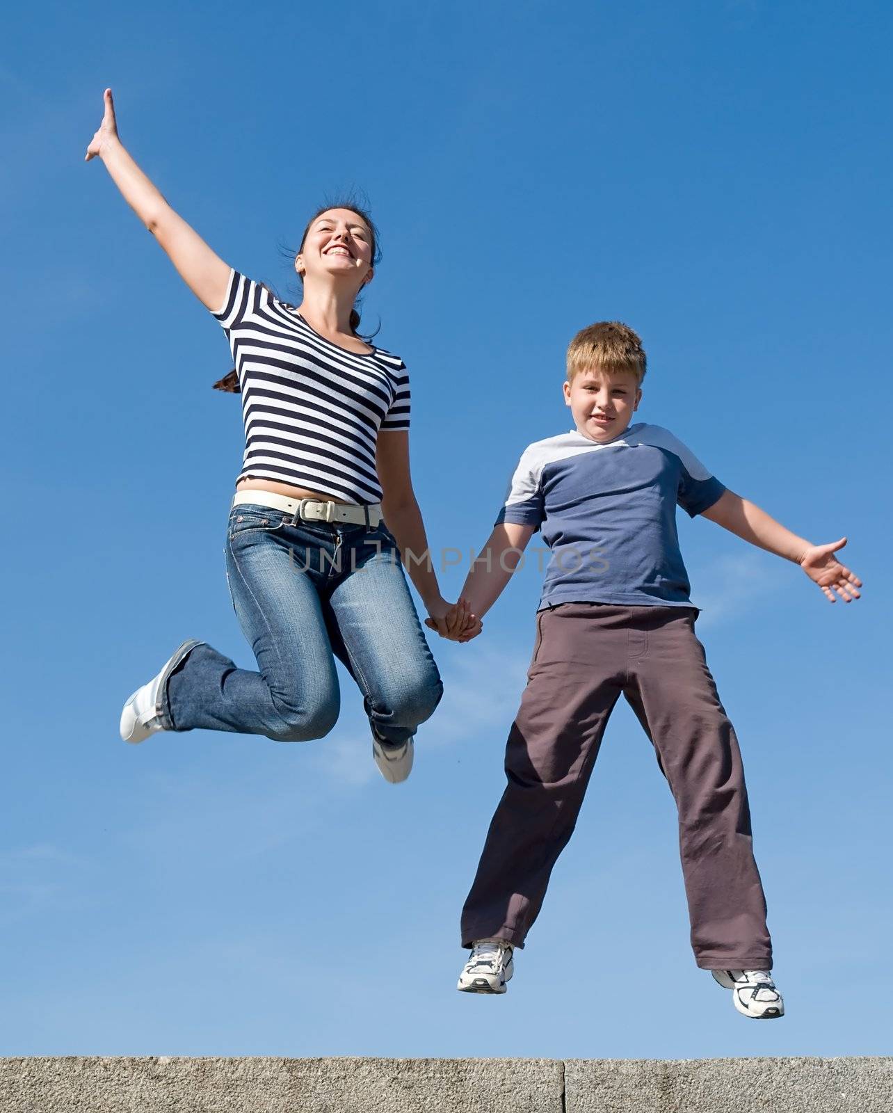 jumping family. Mum and the son with blue sky at background