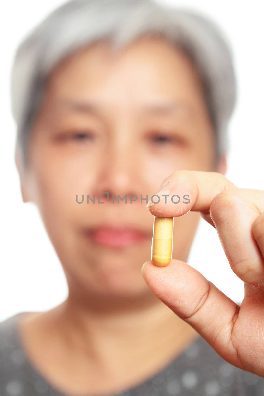 mature woman holding pill