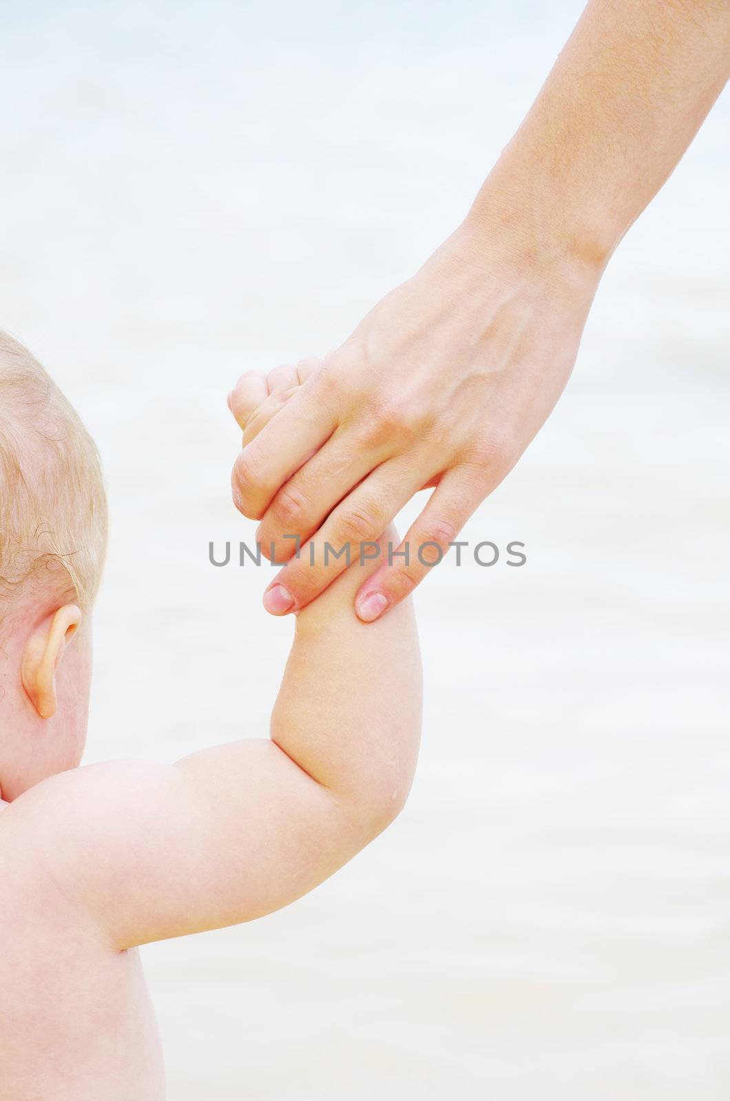 Baby hand holding mother finger isolated on white