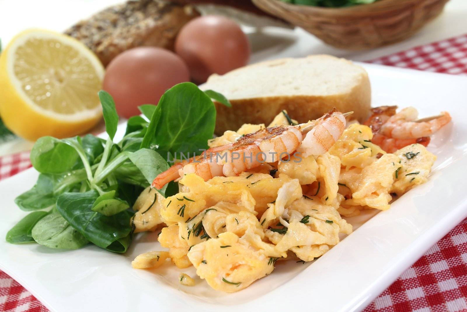 Scrambled eggs with shrimp, dill and corn salad on a plate