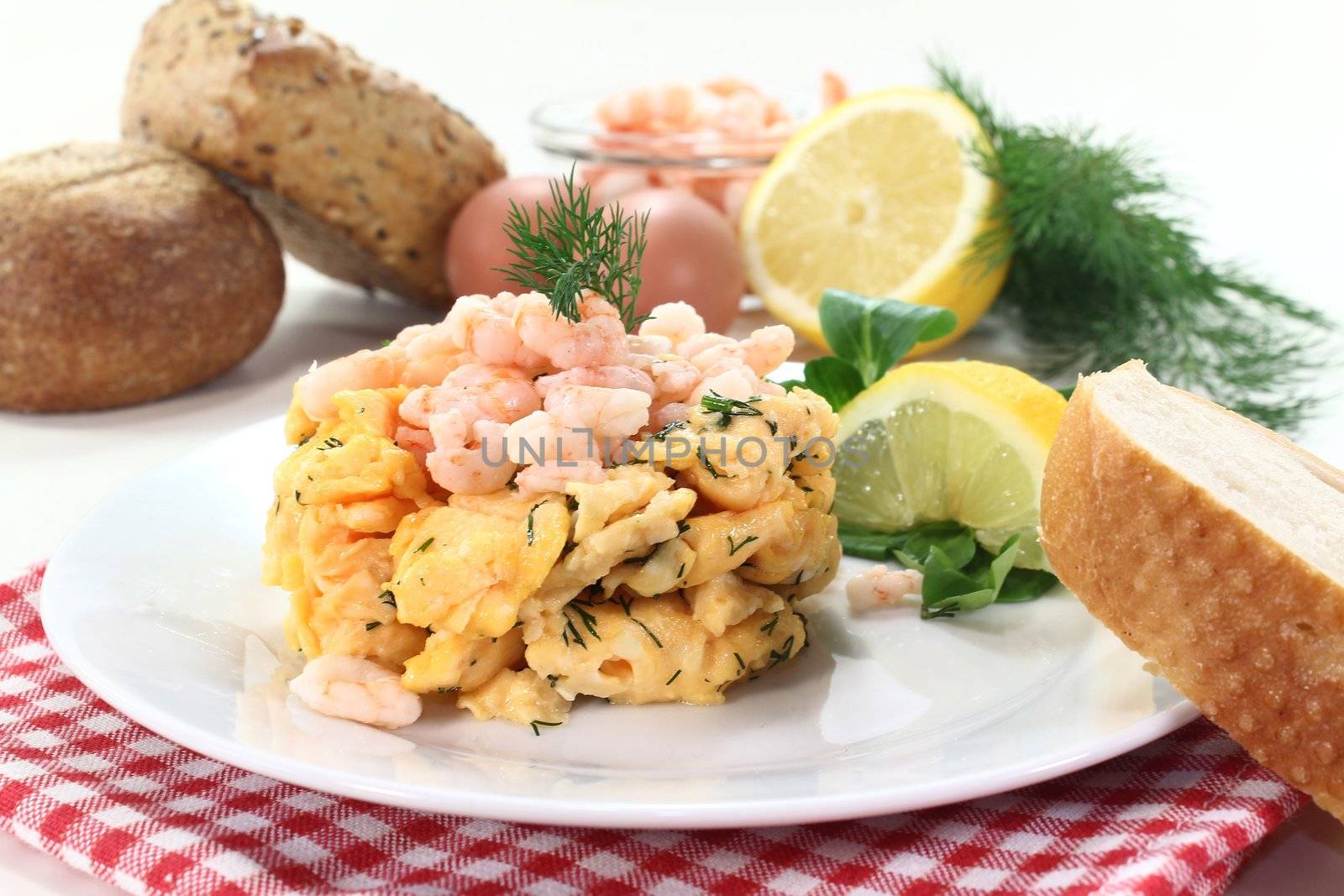 Scrambled eggs with shrimp, dill and corn salad on a plate