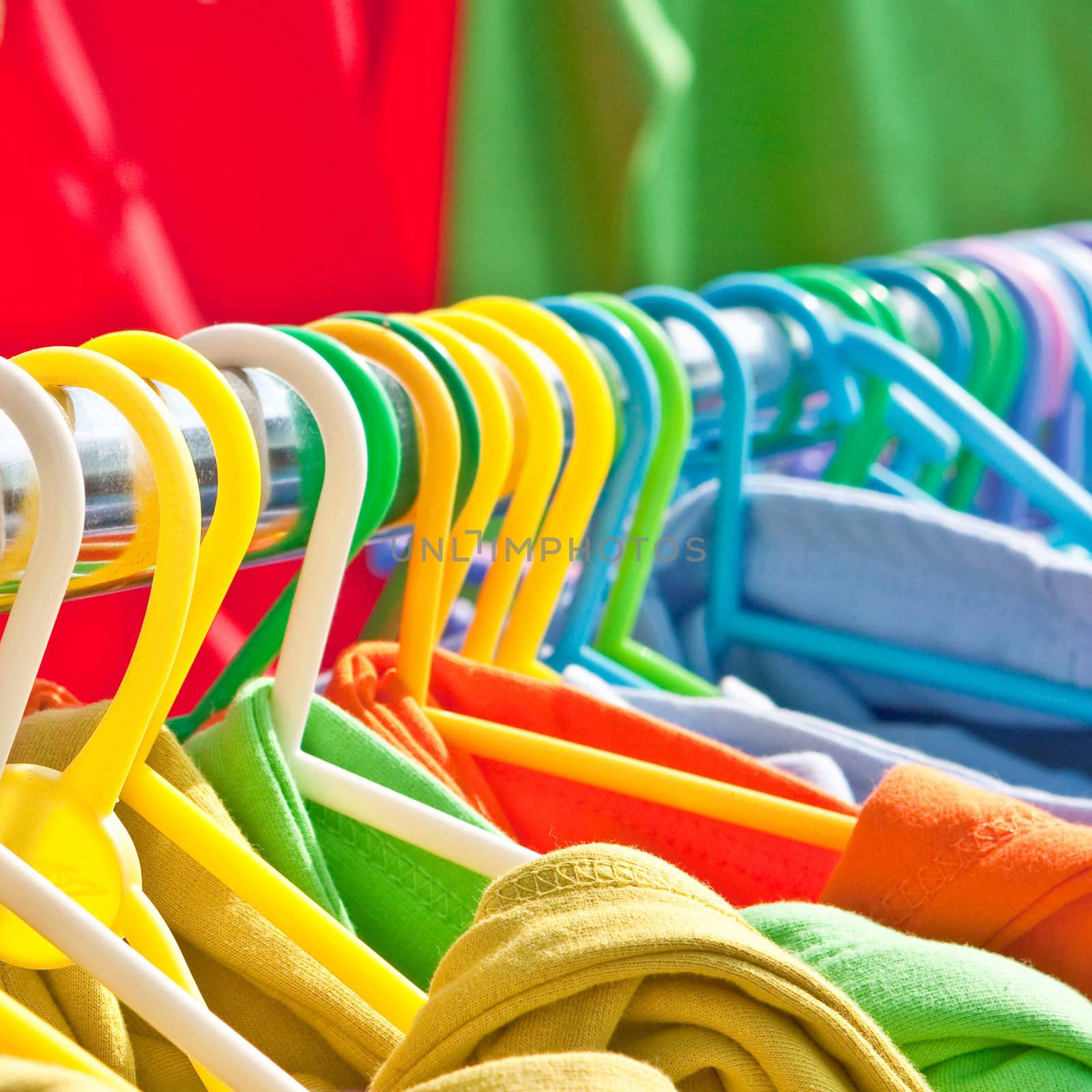 A row of colorful clothes on plastic hangers