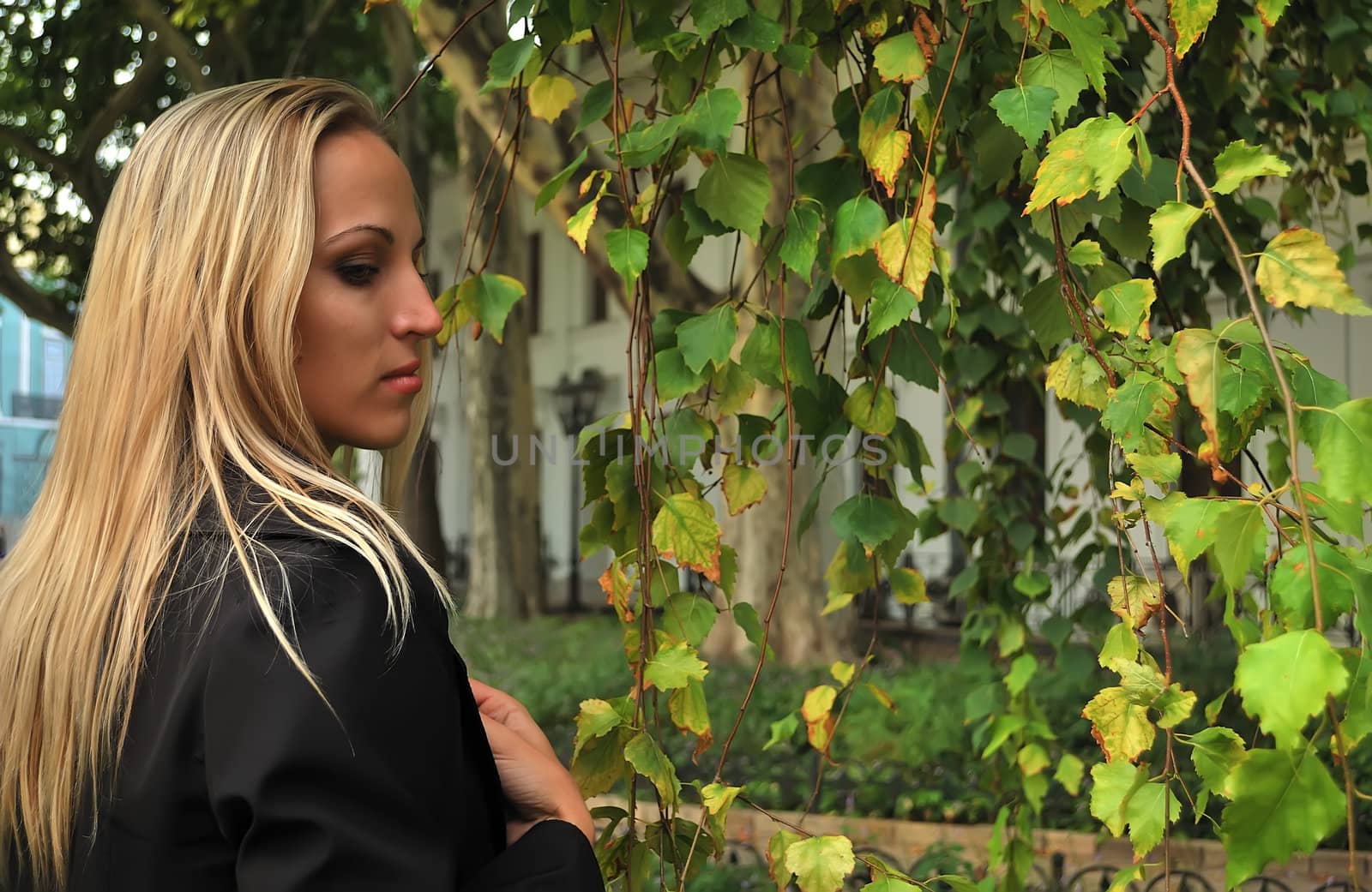 blond girl on a background of leaves