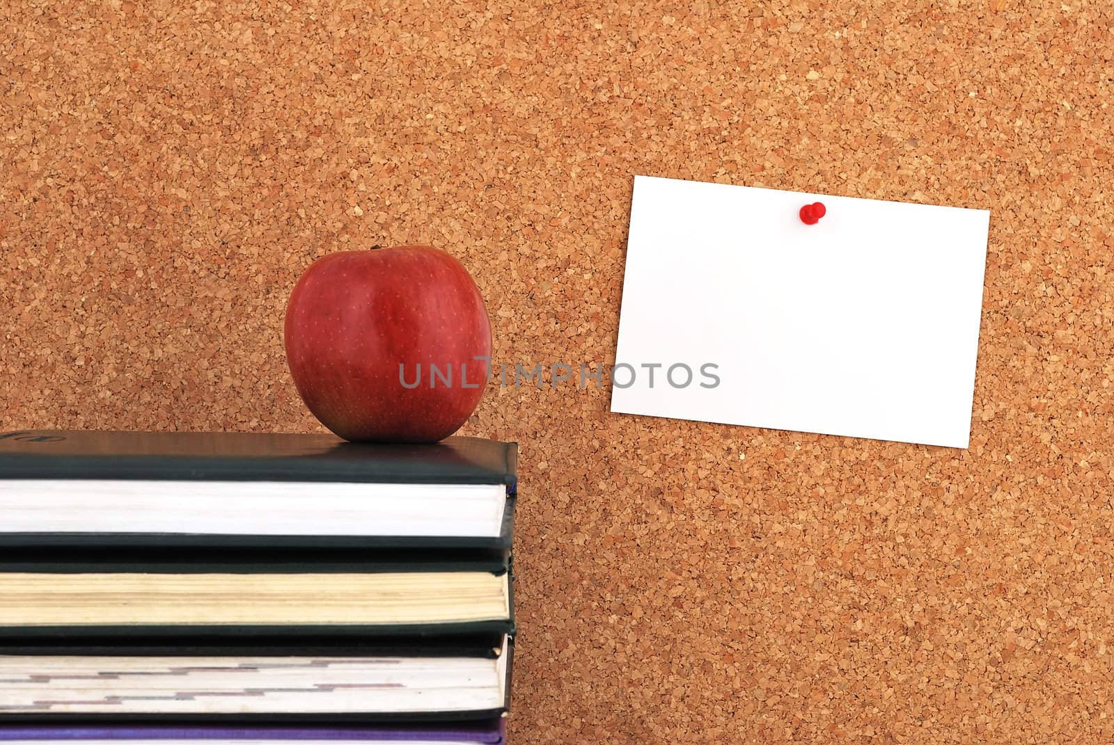 apple and books. against the background of the inscription cork board
