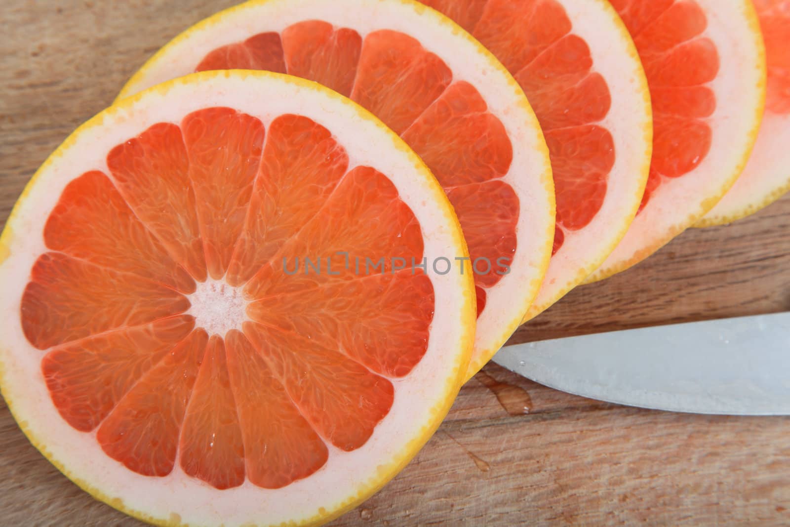 Fresh slices of pink grapefruit on a woodcutter