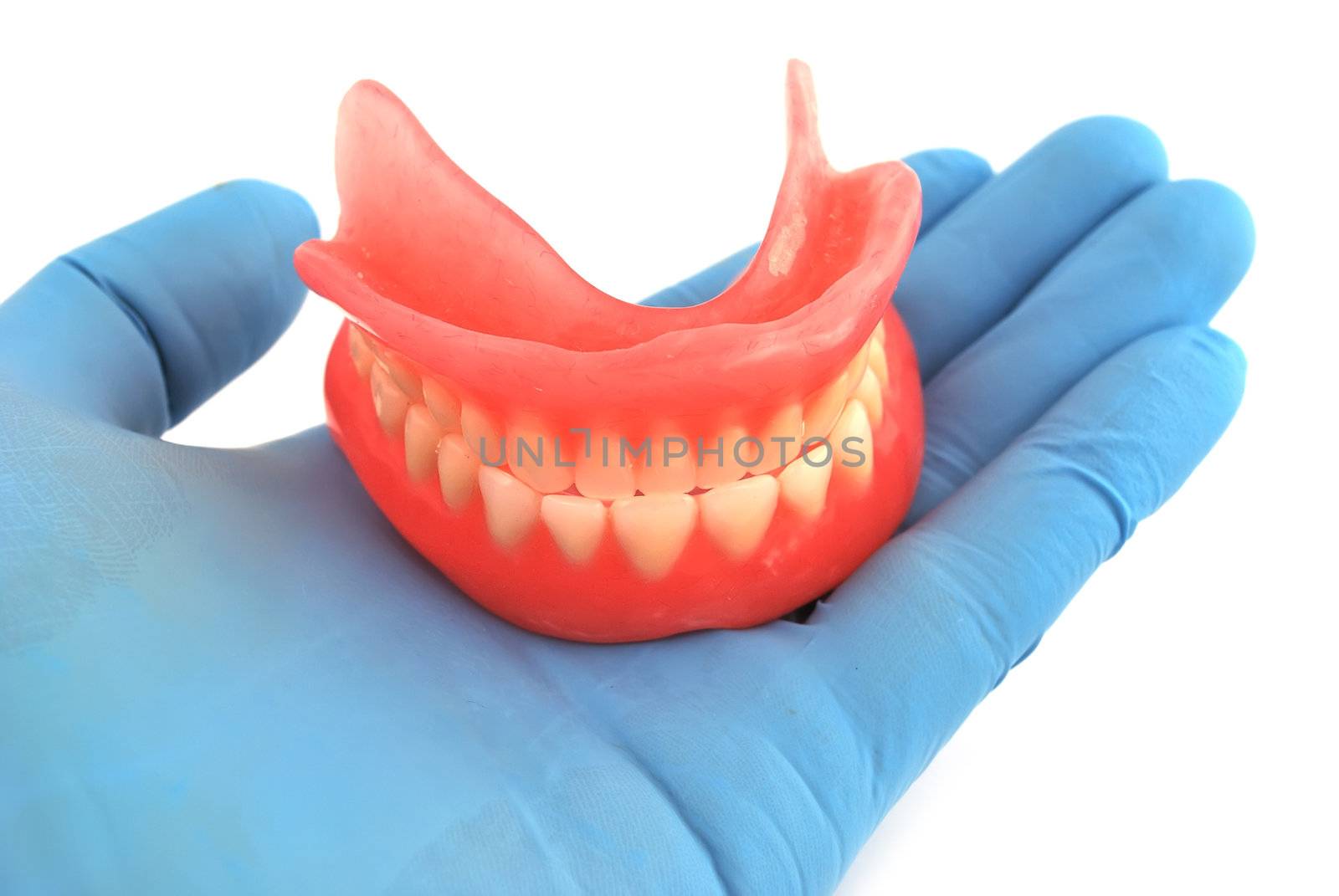 dentures in his hand on a white background