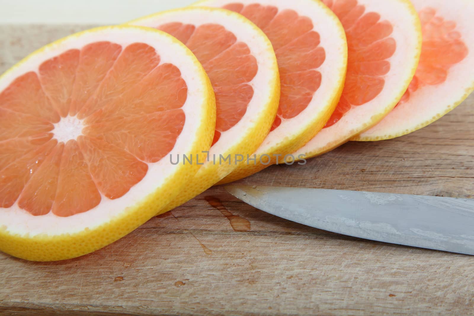 Fresh slices of pink grapefruit on a woodcutter