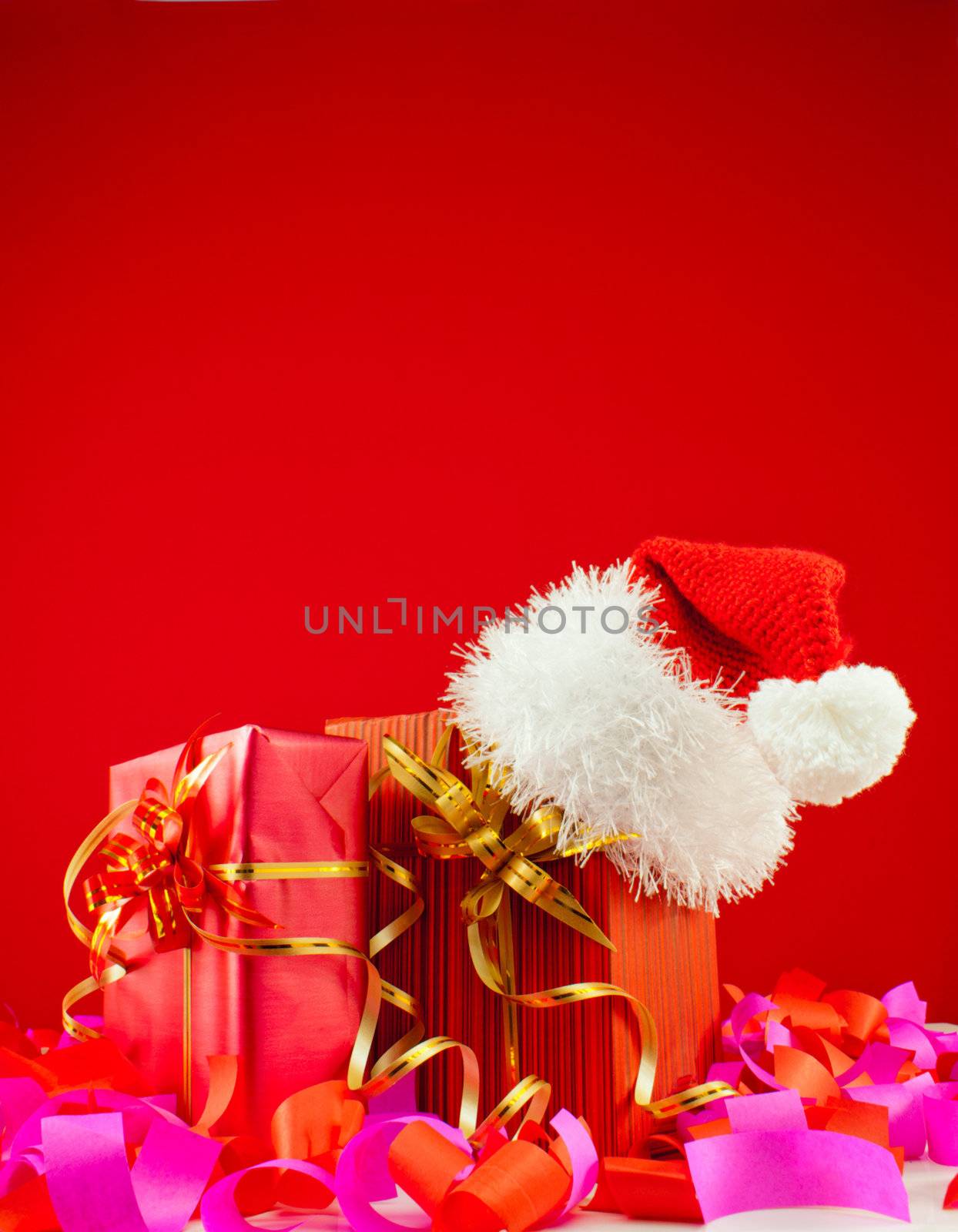 Christmas presents with Santa's hat against red background