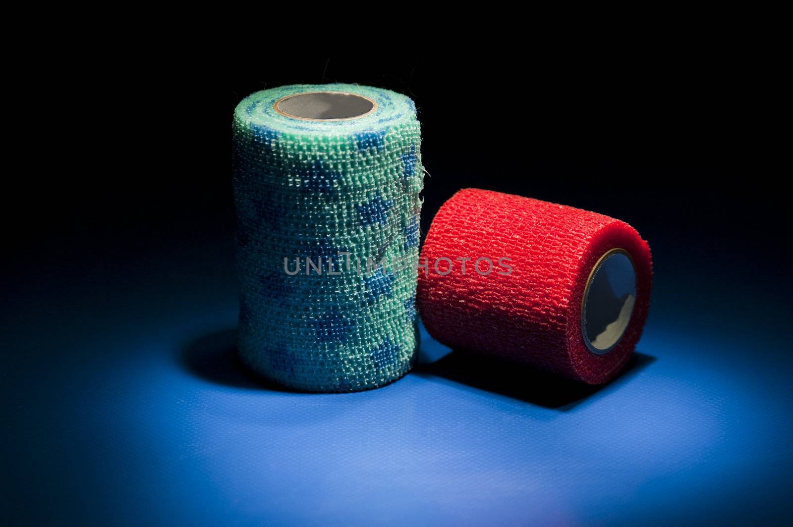 Two different colour medical bandages on studio floor