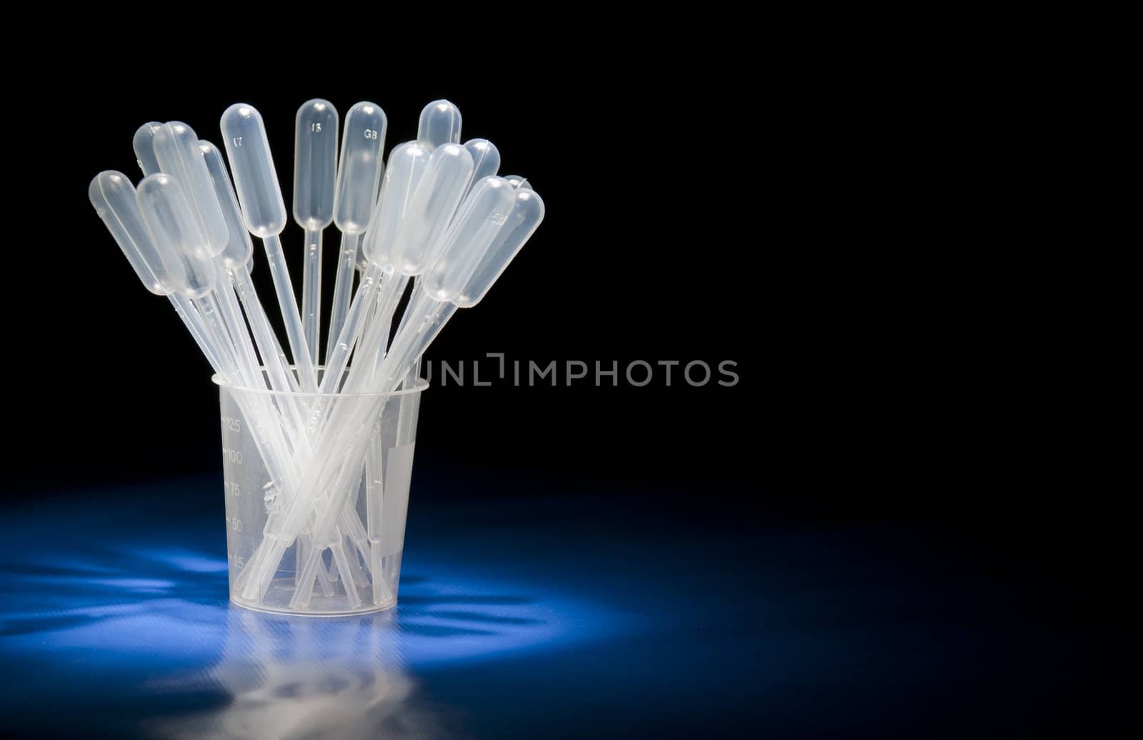 Pack of pipettes standing in glass in studio