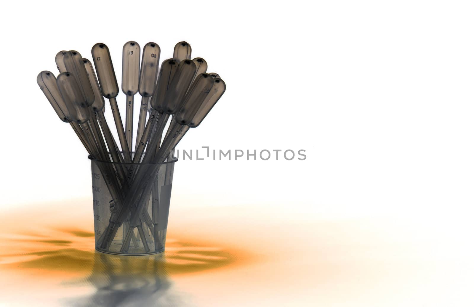 Shaded pack of pipettes standing in measure glass