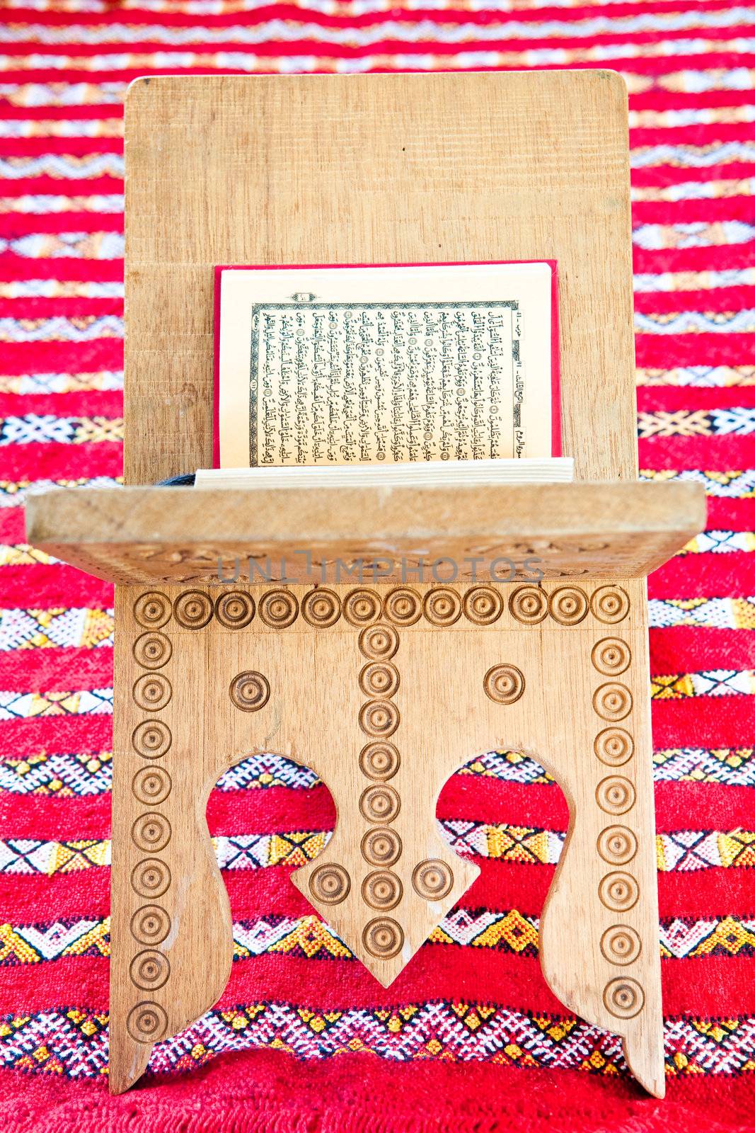 Warsh quran open on a wooden stand on a red Moroccan rug by trgowanlock