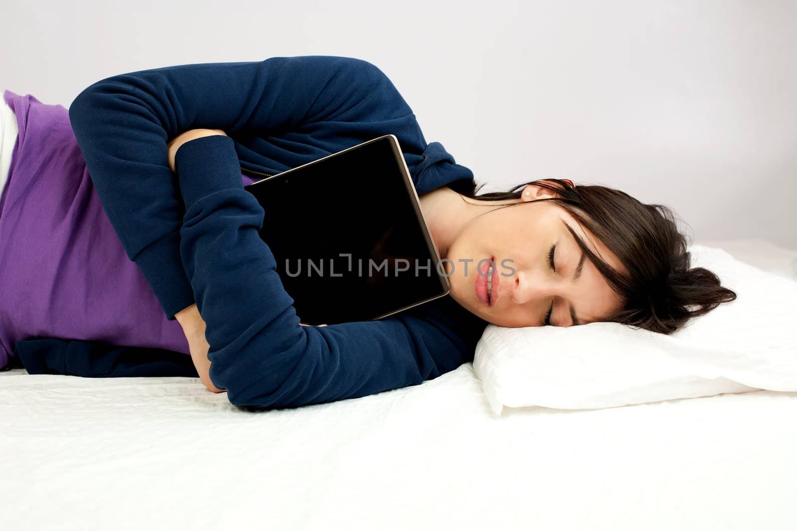 Young woman sleeping happy with tablet computer in her arms