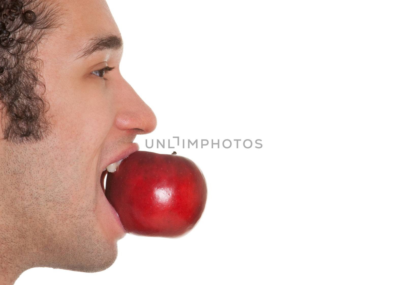 Young man eating red apple