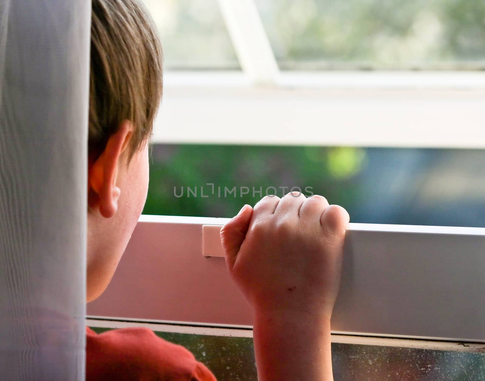 litlle boy looking out of a window