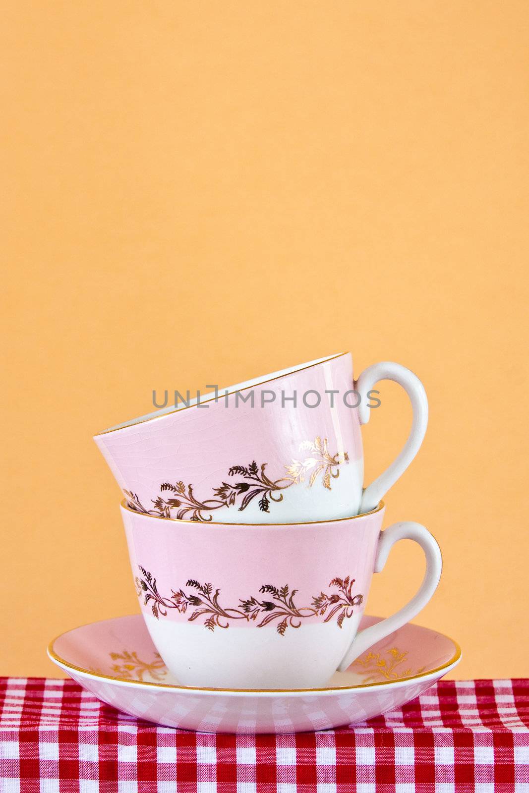 Two retro style teacups on gingham cloth by trgowanlock