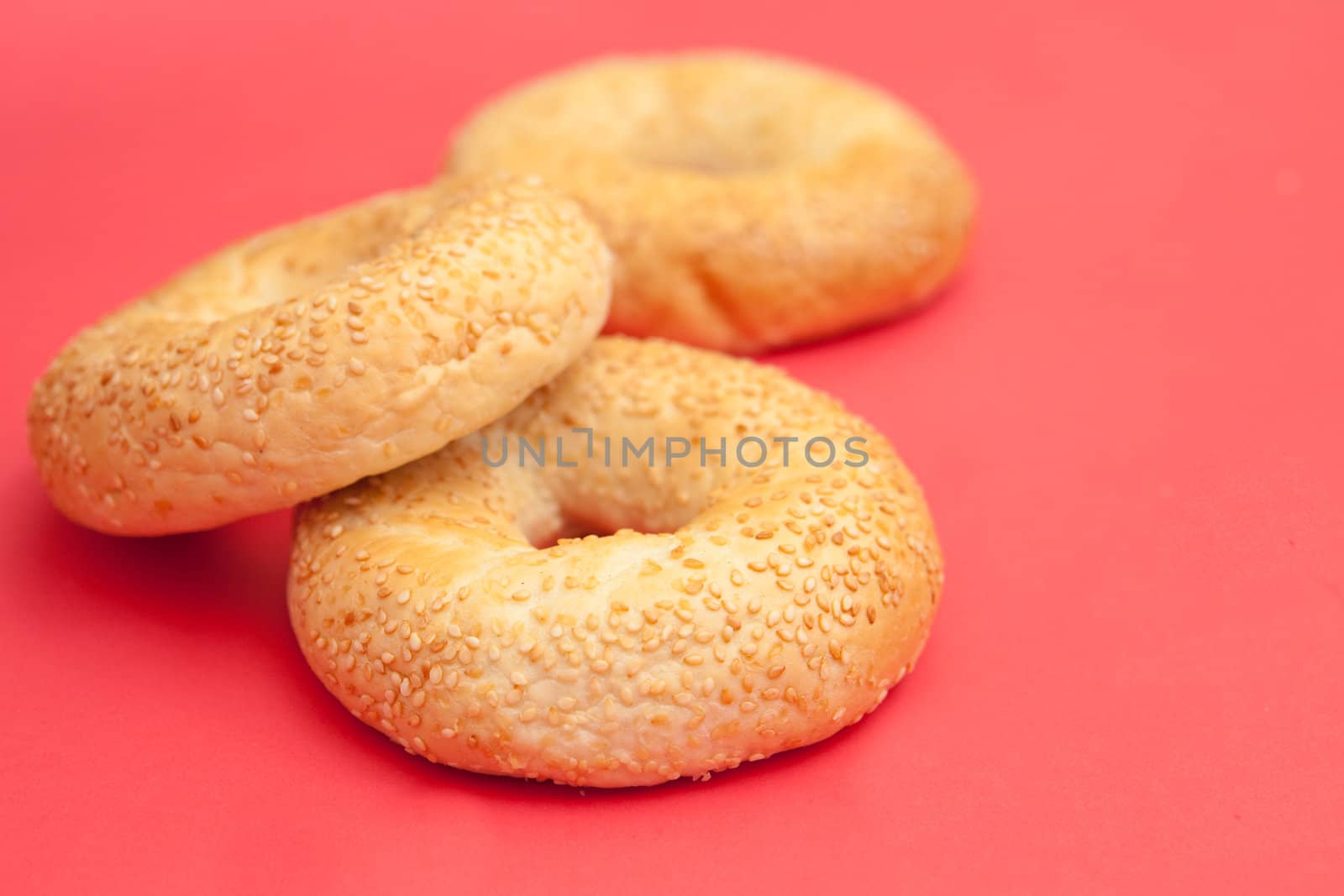 Three fresh bagels on a nice red background