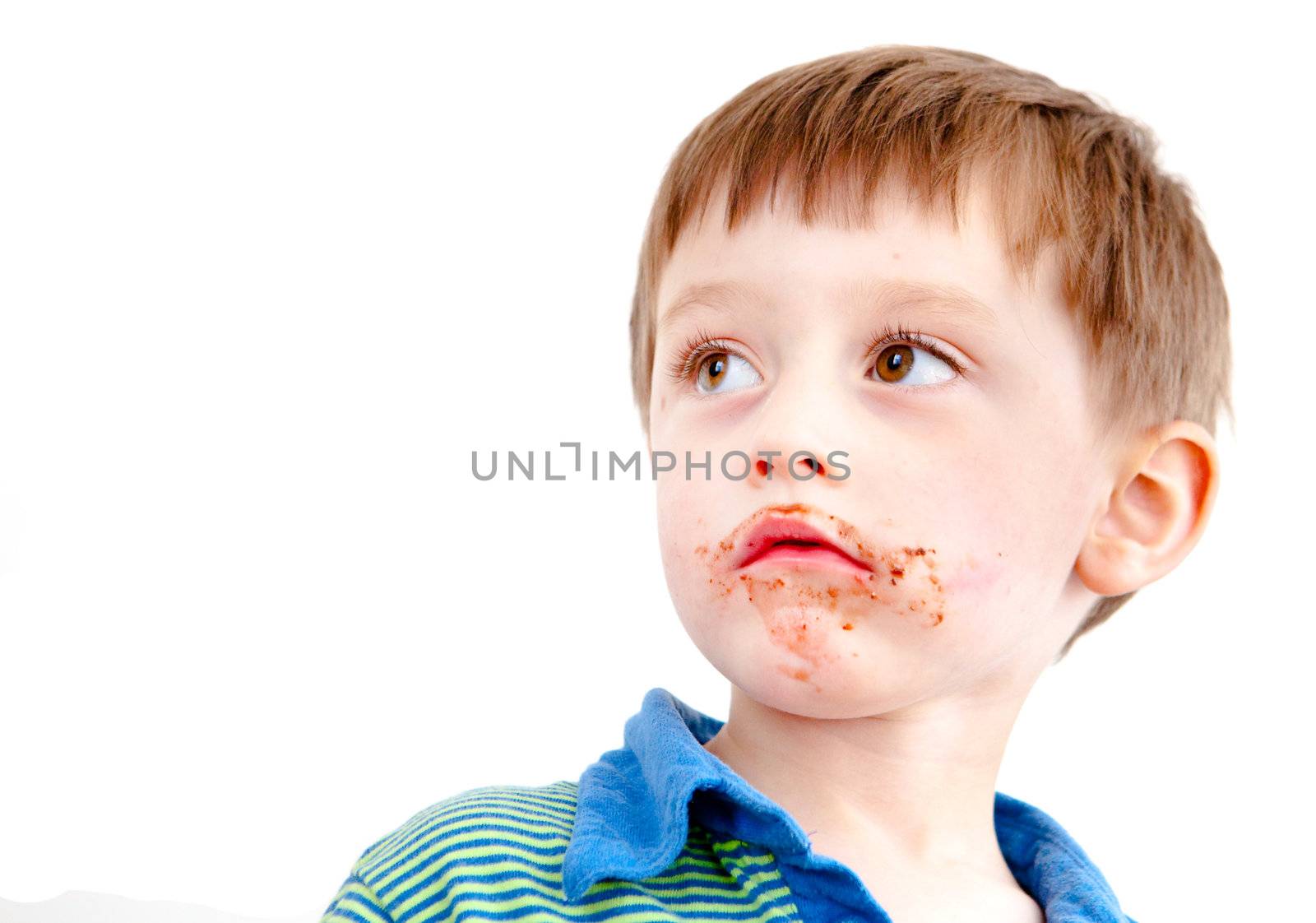 Young boy with chocolate on his face or ice cream isolated on white