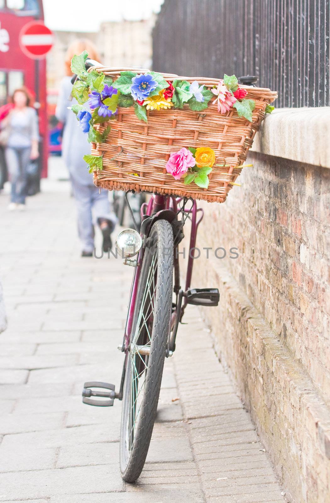 A lady's pedal bike with a colorfully decorated basket