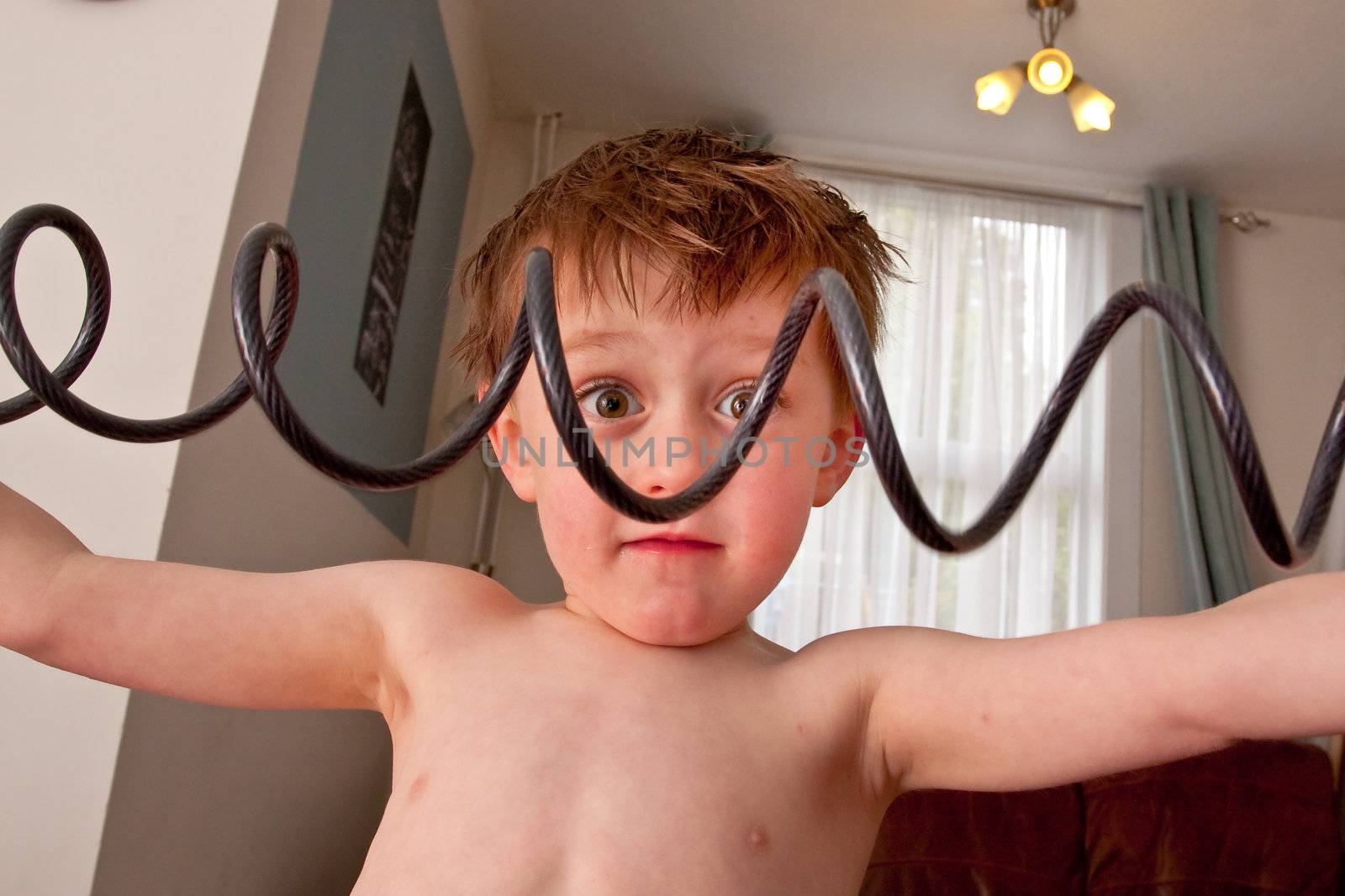 A young boy stretches a coiled bike lock pretending to work out!