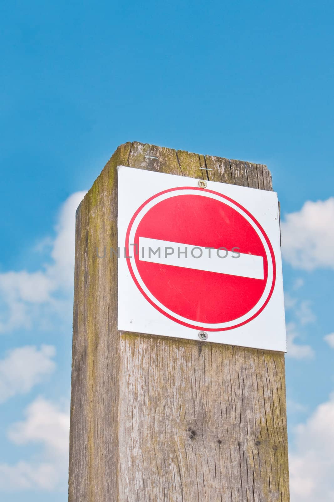 A red no entry sign against a bright blue sky