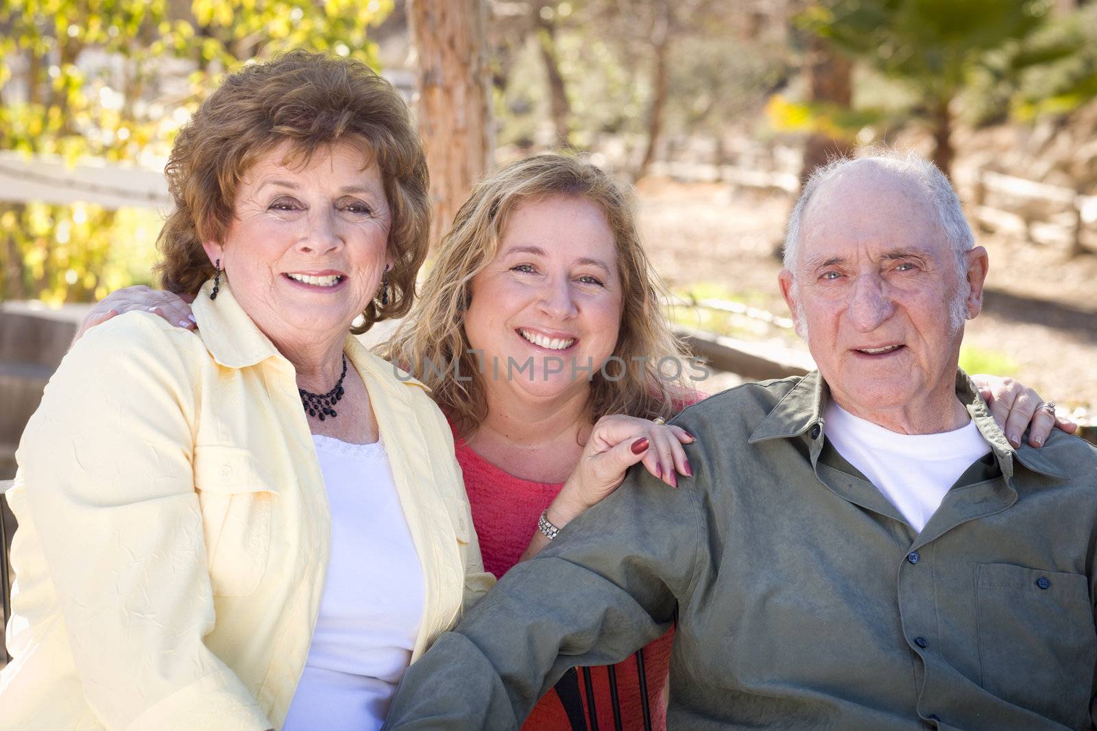 Portrait of Senior Couple with Daughter in the Park.