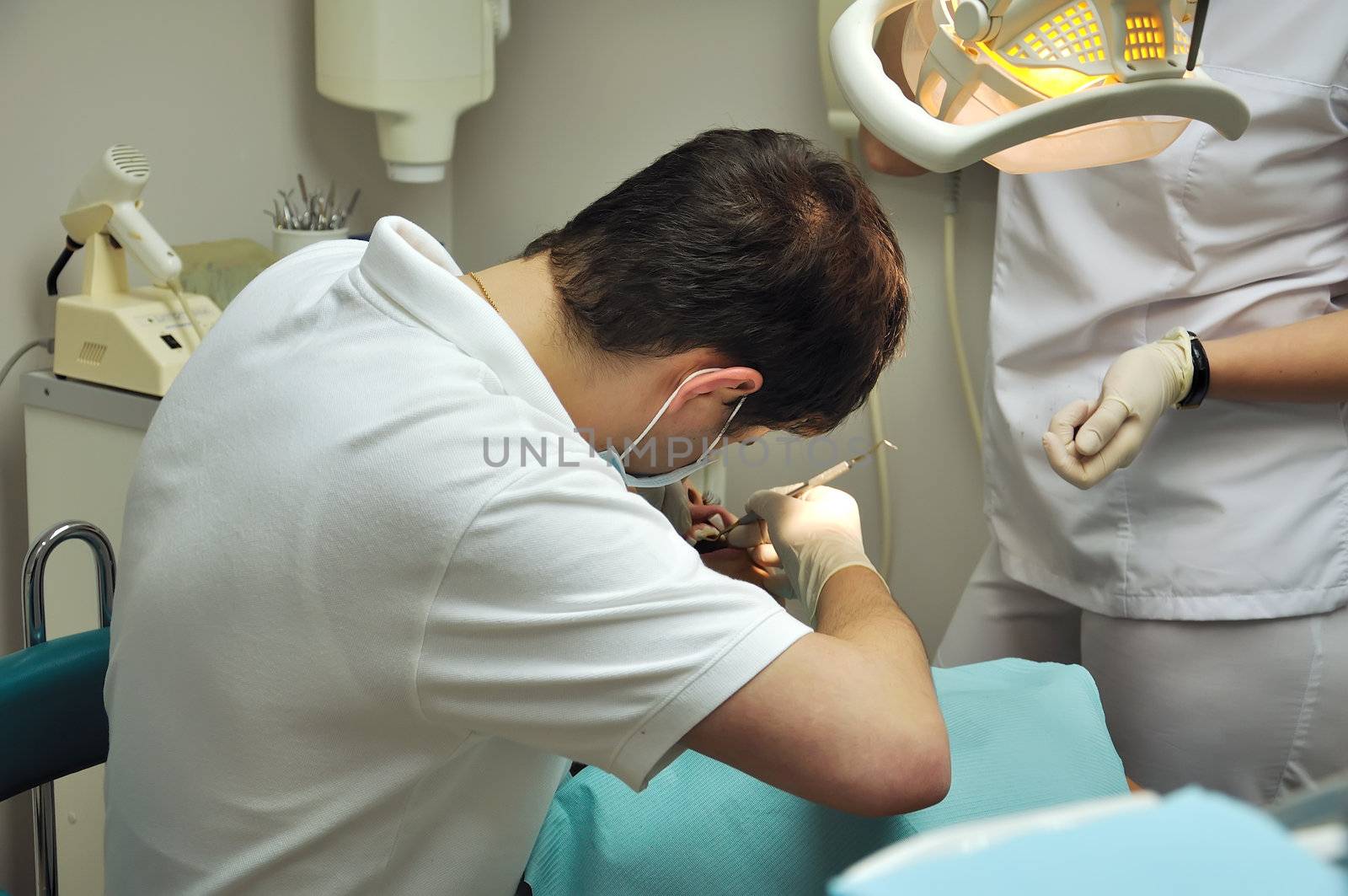 dentist and assistant operate on the patient