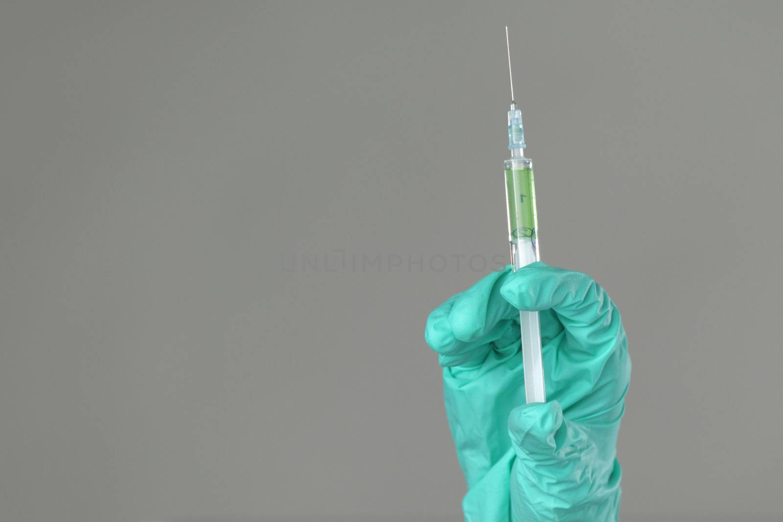 syringe in hand on gray background