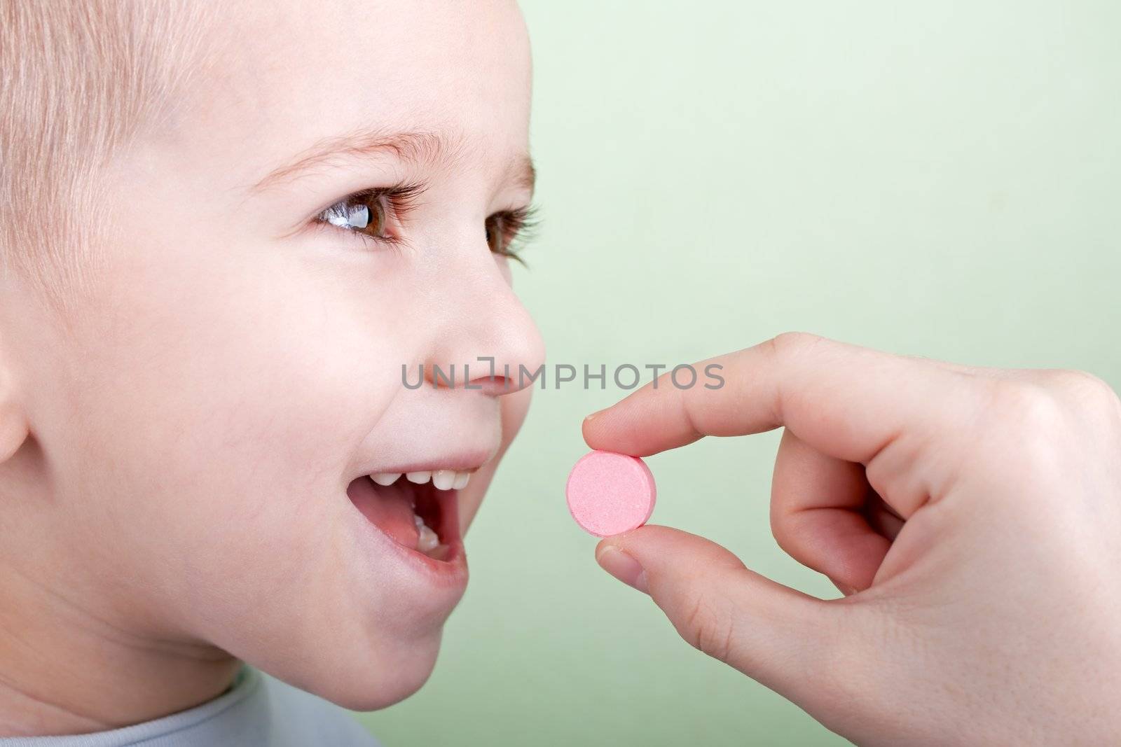 Human hand giving child medicine healthcare pill