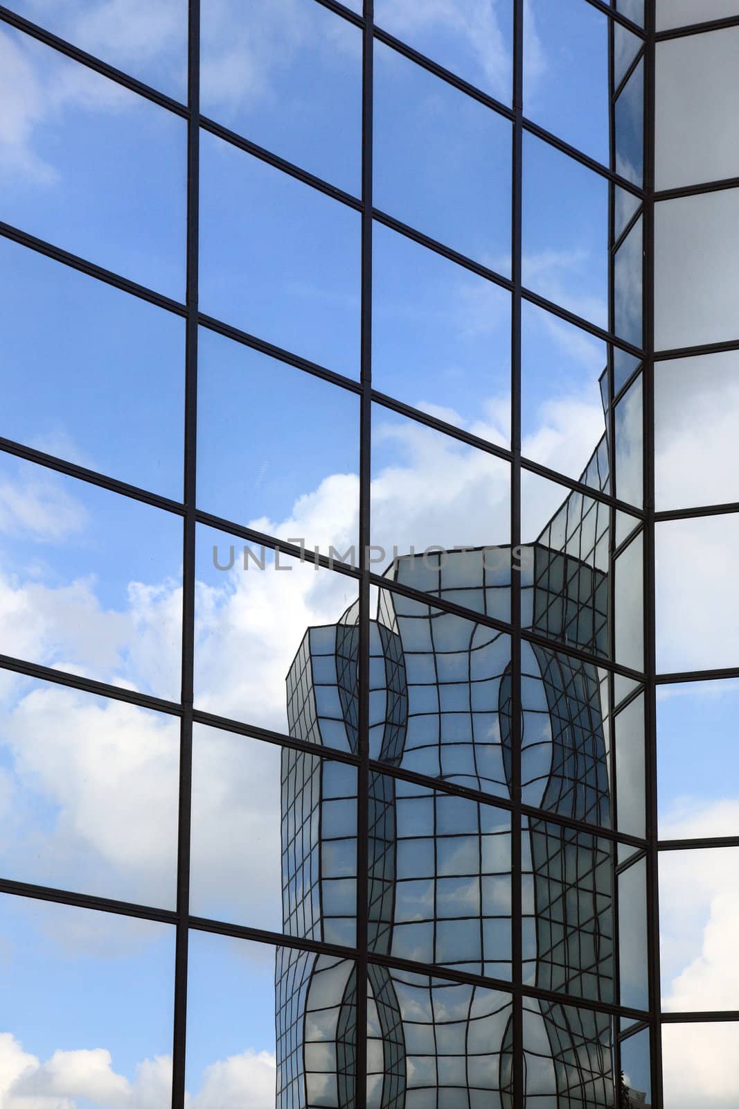 Glass and steel building reflected in glass wall