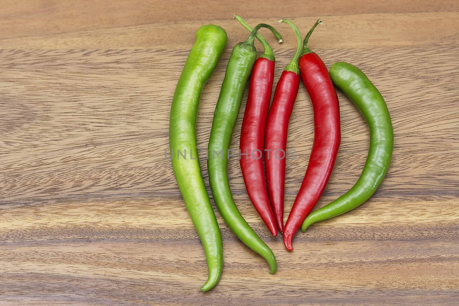 Red hot chili peppers over wooden background 