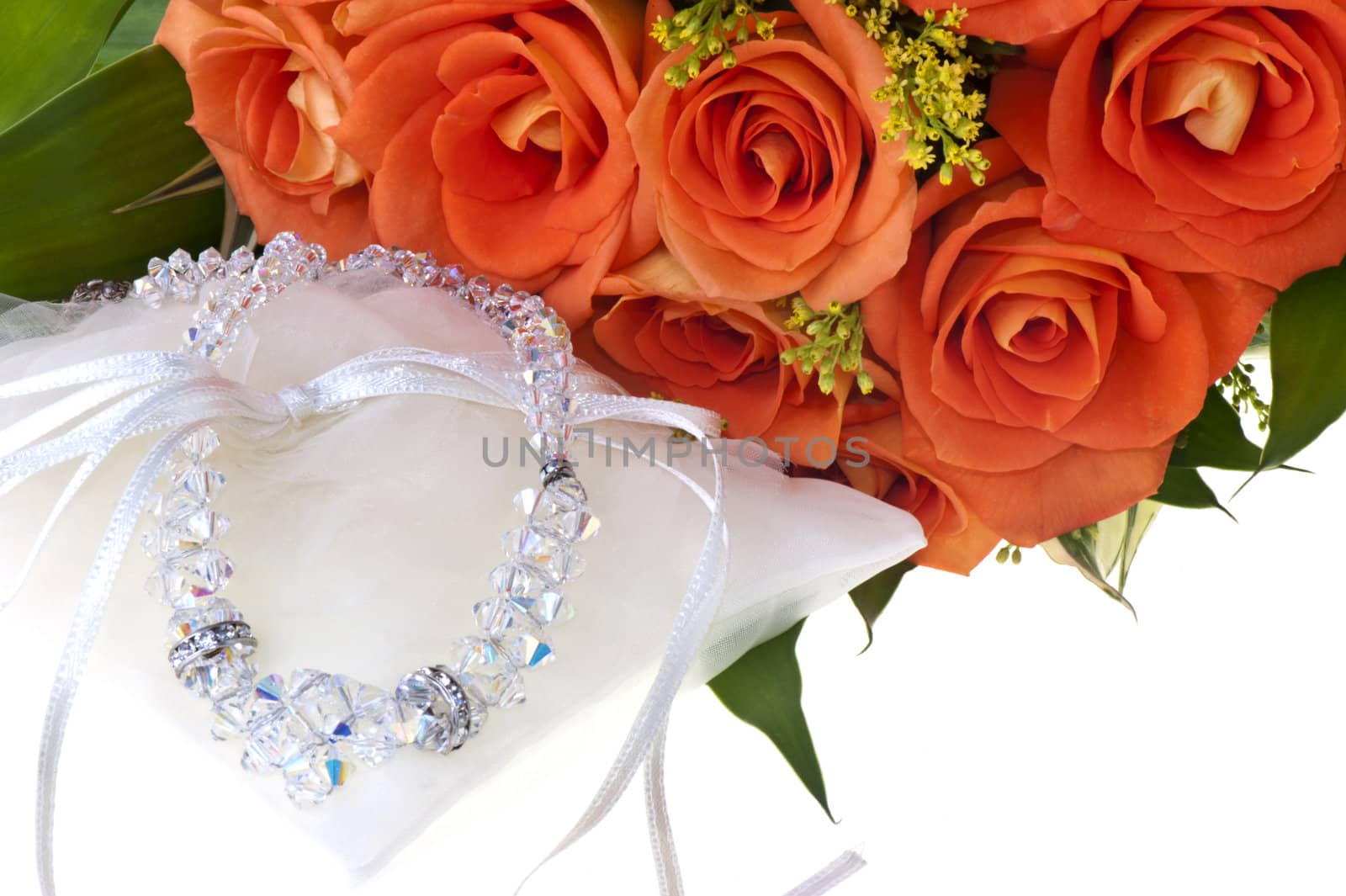 necklace and orange roses on a white background