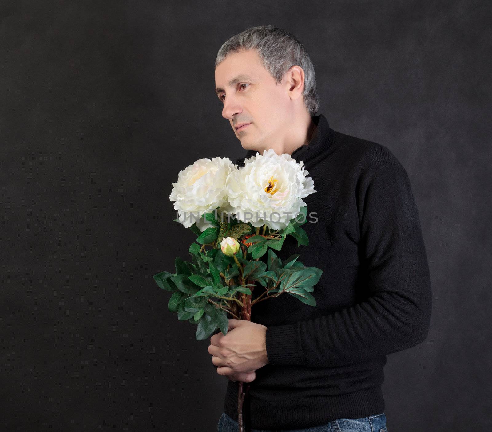 Man holding a bouquet of flowers on gray background