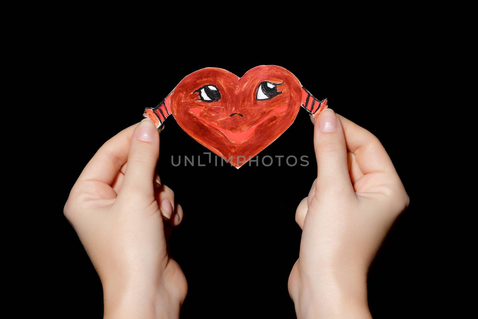 Smiling heart in hands on black background