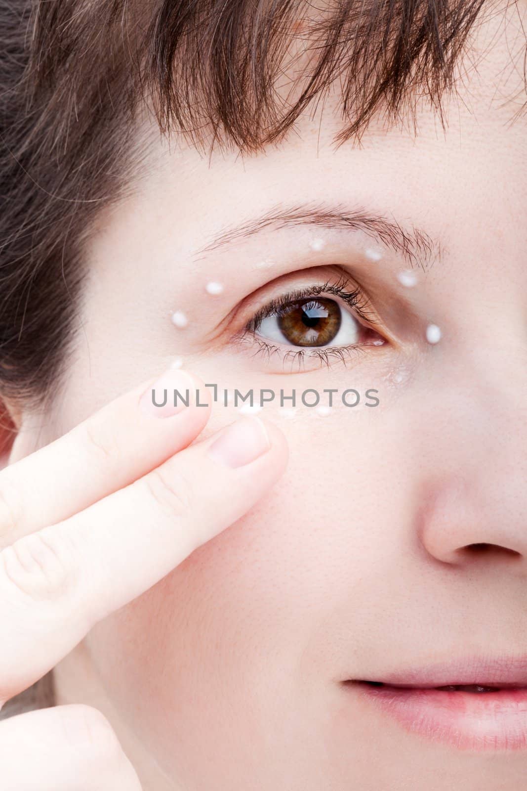 Beauty women applying female eye skin makeup cream