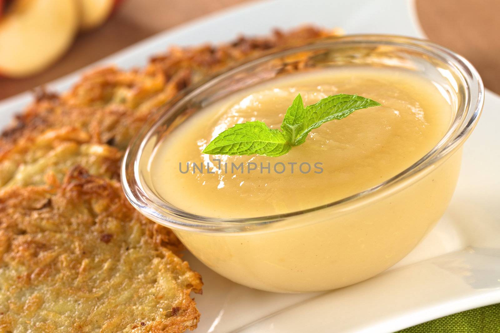 Apple sauce with potato fritters (Selective Focus, Focus on the mint leaf on the apple sauce)