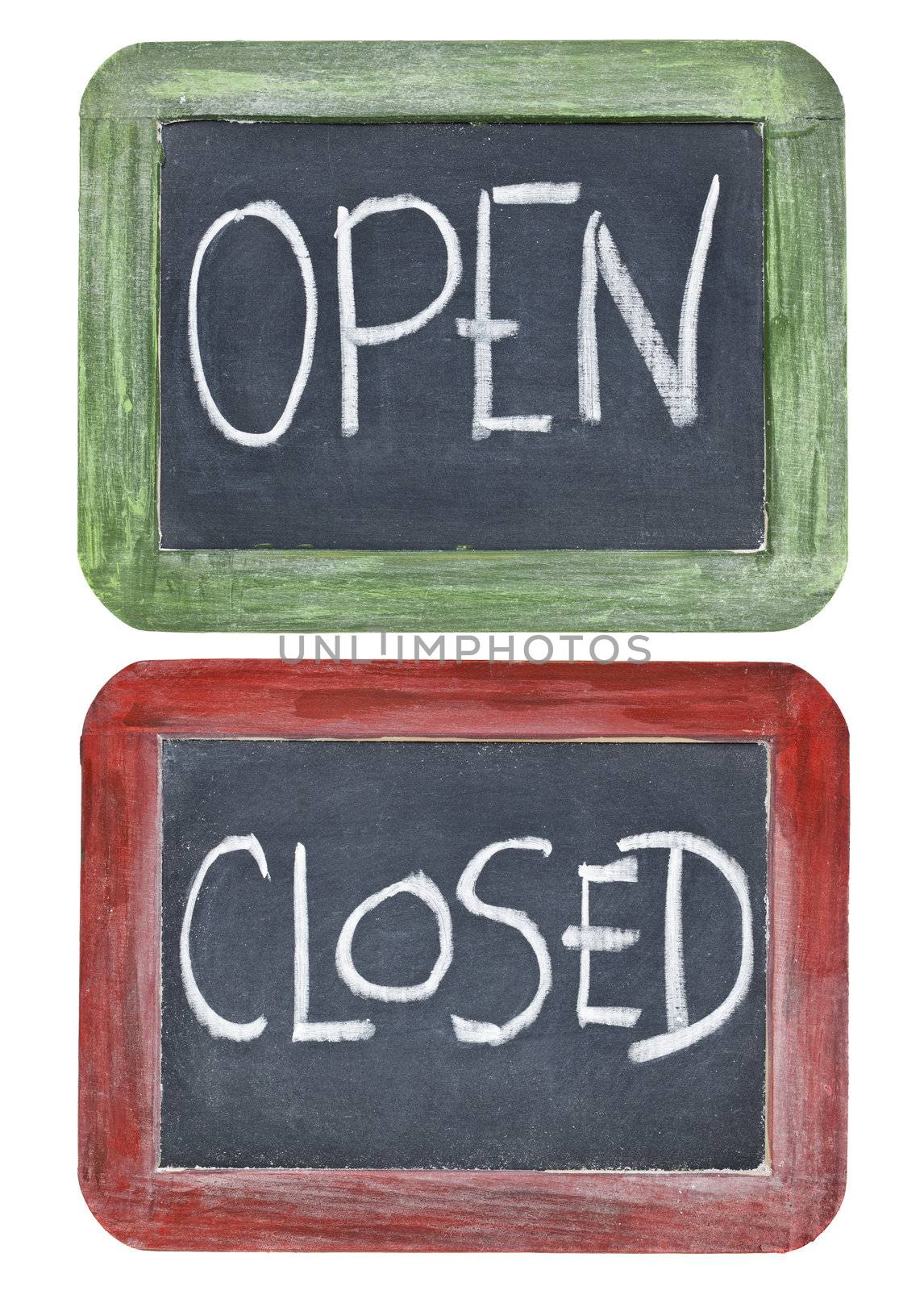 open and closed signs - white chalk handwriting on two small slate blackboards in grunge painted wood frames
