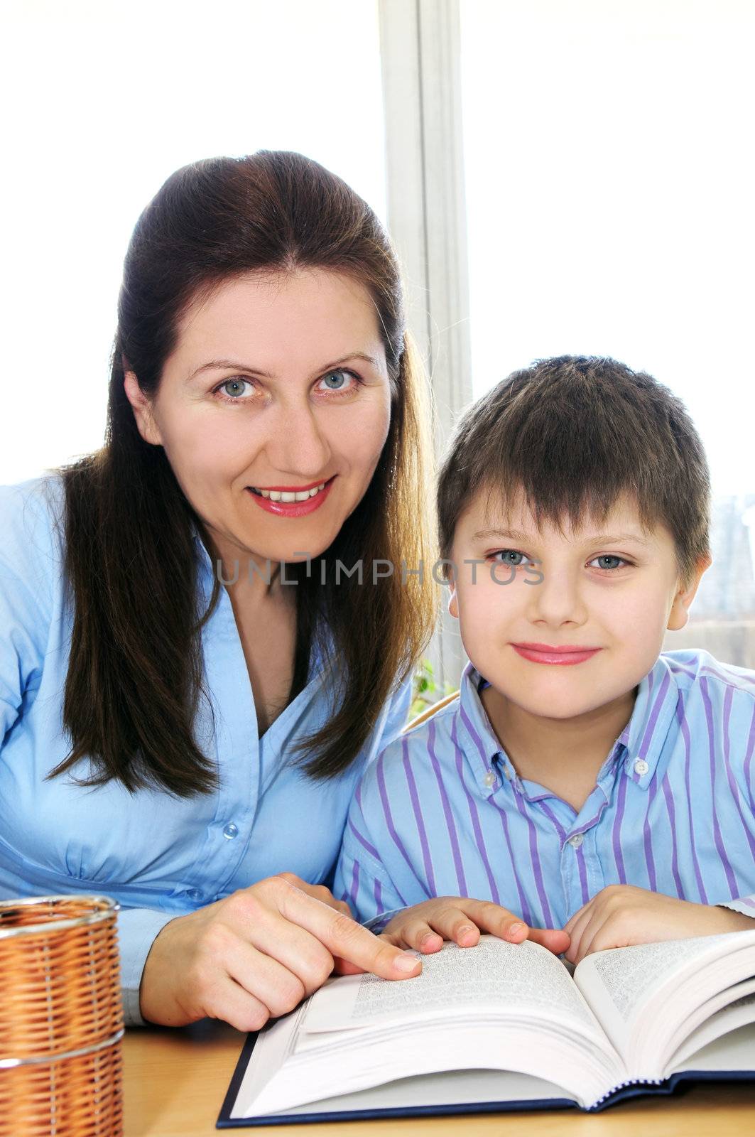 Teacher or tutor helping school boy to study