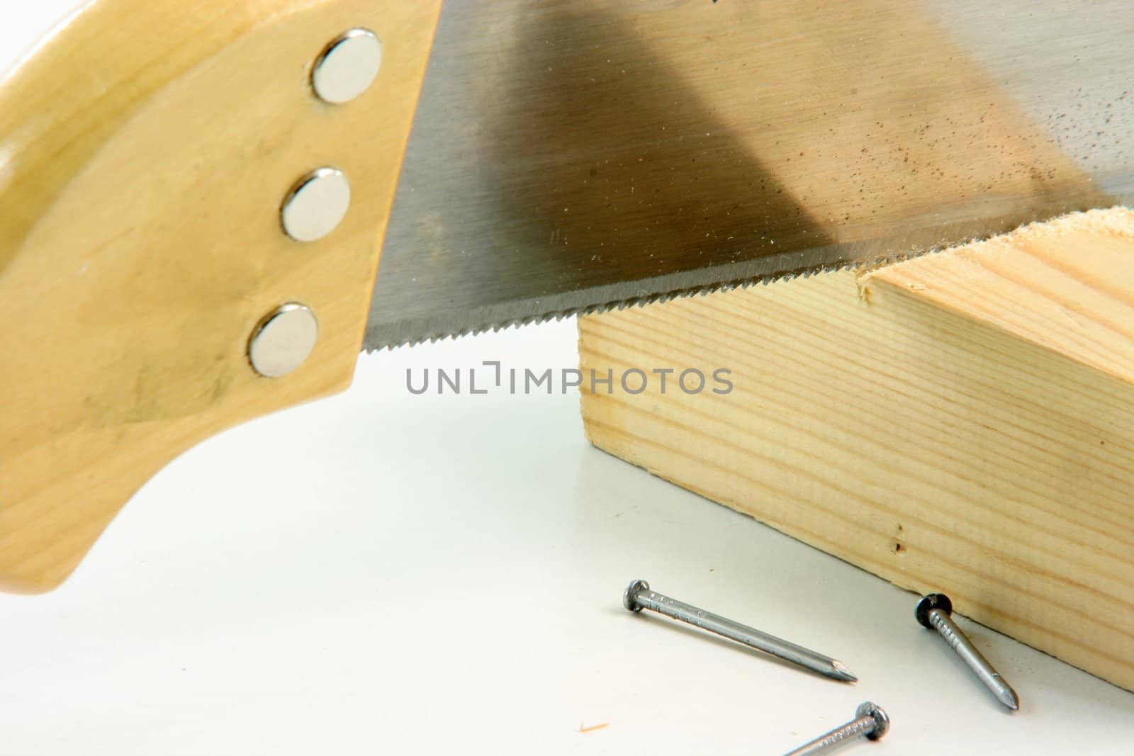 hand saw cutting wood and construction nails in white background construction concepts detail