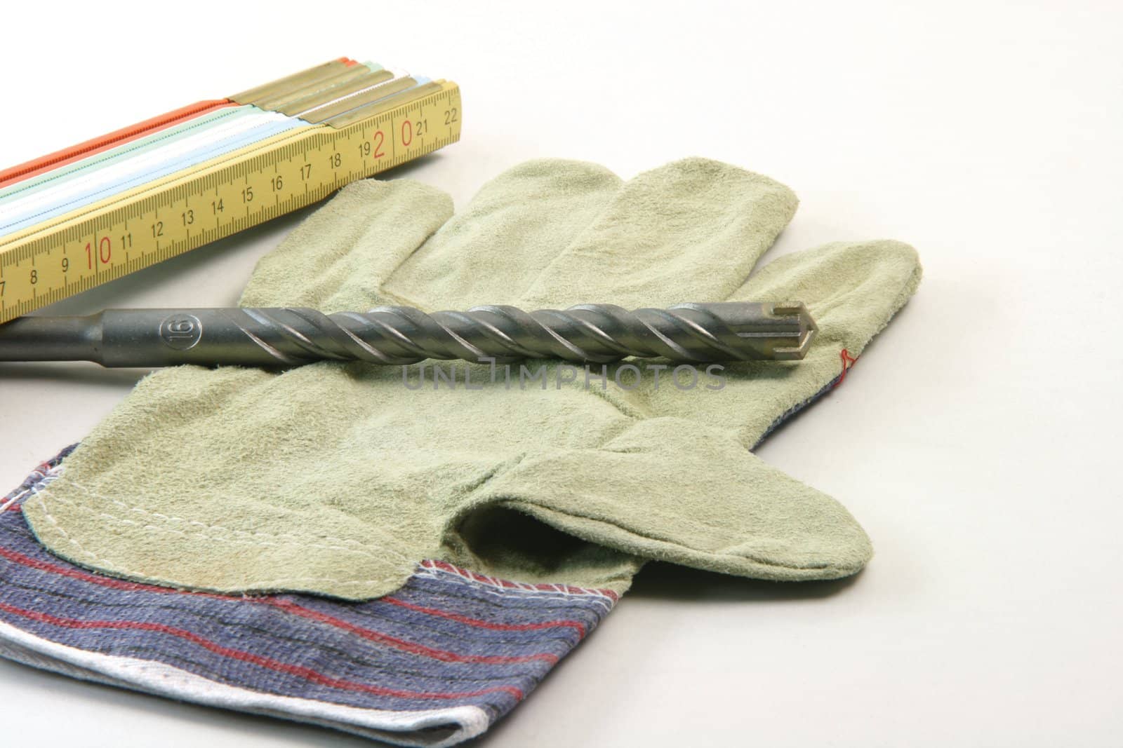 contruction concepts meter drill and working gloves in white background